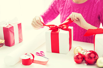 Image showing close up of woman decorating christmas presents