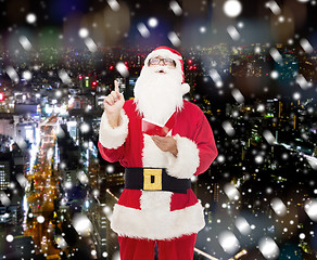 Image showing man in costume of santa claus with notepad