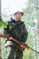 Image showing young soldier or hunter with gun in forest