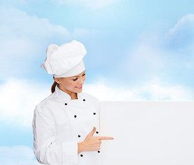 Image showing smiling female chef with white blank board