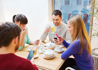 Image showing group of friends with smartphones meeting at cafe