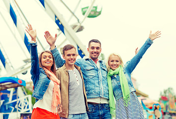 Image showing group of smiling friends waving hands