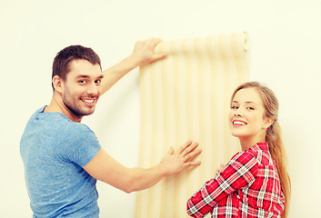 Image showing smiling couple choosing wallpaper for new home