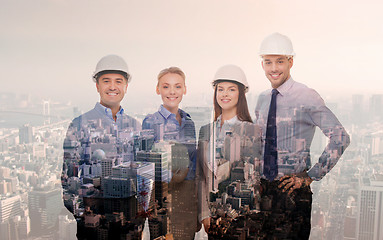 Image showing happy businessmen in helmets over city background