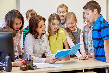 Image showing group of school kids with teacher in classroom