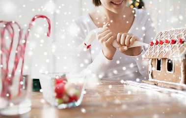 Image showing close up of woman making gingerbread houses