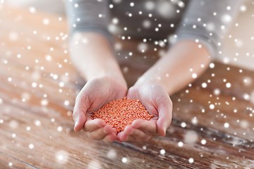 Image showing close up of woman emptying jar with red lentils