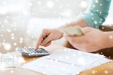 Image showing close up of man counting money and making notes