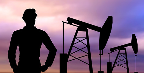 Image showing black silhouette of oil worker and pump jack