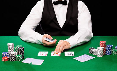 Image showing holdem dealer with playing cards and casino chips