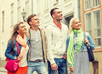 Image showing group of smiling friends walking in the city