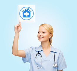 Image showing smiling doctor or nurse pointing to pills icon