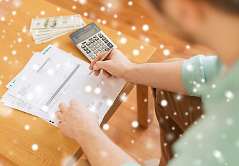 Image showing close up of man counting money and making notes