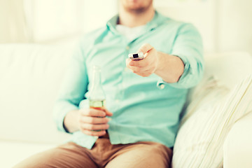 Image showing man with beer and remote control at home