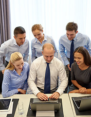 Image showing smiling business people with laptop in office