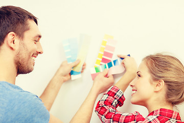 Image showing smiling couple looking at color samples at home