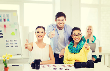 Image showing smiling team with photocamera in office