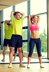 Image showing smiling man and woman exercising in gym