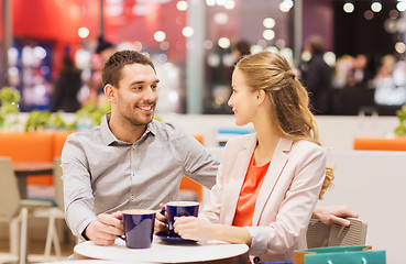 Image showing happy couple with shopping bags drinking coffee