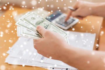 Image showing close up of man counting money and making notes