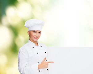 Image showing smiling female chef with white blank board