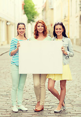 Image showing smiling teenage girls with blank billboard
