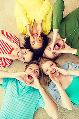 Image showing smiling people lying down on floor and screaming