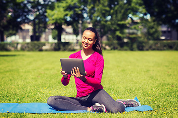 Image showing smiling woman with tablet pc outdoors