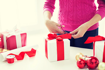 Image showing close up of woman decorating christmas presents