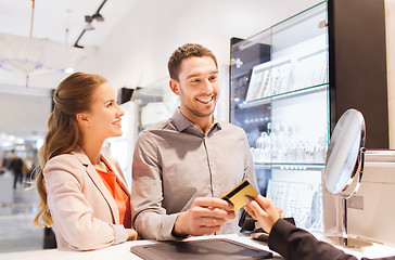 Image showing happy couple choosing engagement ring in mall