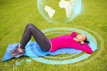 Image showing smiling woman doing exercises on mat outdoors