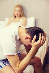 Image showing man sitting on the bed with woman on the back