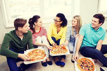 Image showing five smiling teenagers eating pizza at home