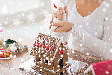 Image showing close up of woman making gingerbread house at home