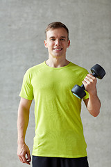 Image showing smiling man with dumbbell in gym