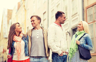 Image showing group of smiling friends walking in the city