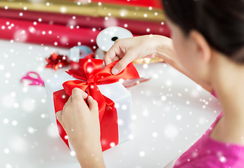 Image showing close up of woman decorating christmas present