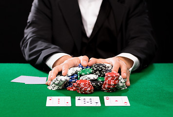 Image showing poker player with cards and chips at casino