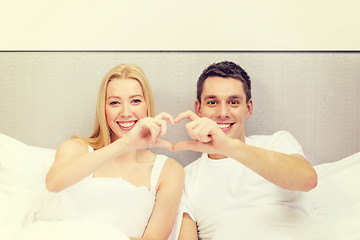 Image showing smiling couple showing heart with hands