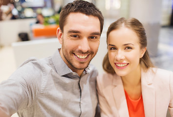 Image showing happy couple taking selfie in mall or office