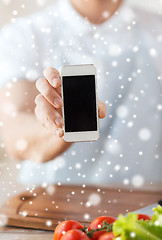 Image showing closeup of man showing smartphone in kitchen