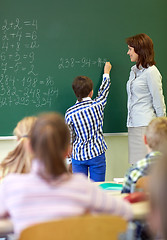 Image showing teacher and schoolboy writing on chalk board