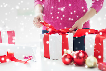 Image showing close up of woman decorating christmas presents