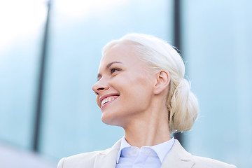 Image showing young smiling businesswoman over office building