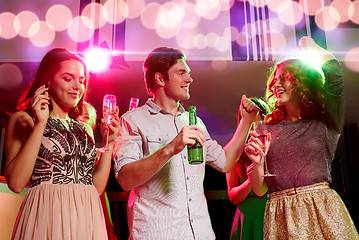 Image showing smiling friends with wine glasses and beer in club