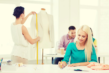 Image showing smiling fashion designers working in office