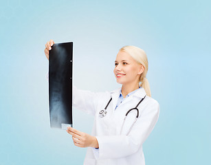 Image showing smiling female doctor looking at x-ray image