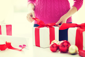 Image showing close up of woman decorating christmas presents