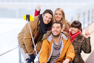 Image showing happy friends with smartphone on skating rink