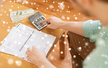 Image showing close up of man counting money and making notes